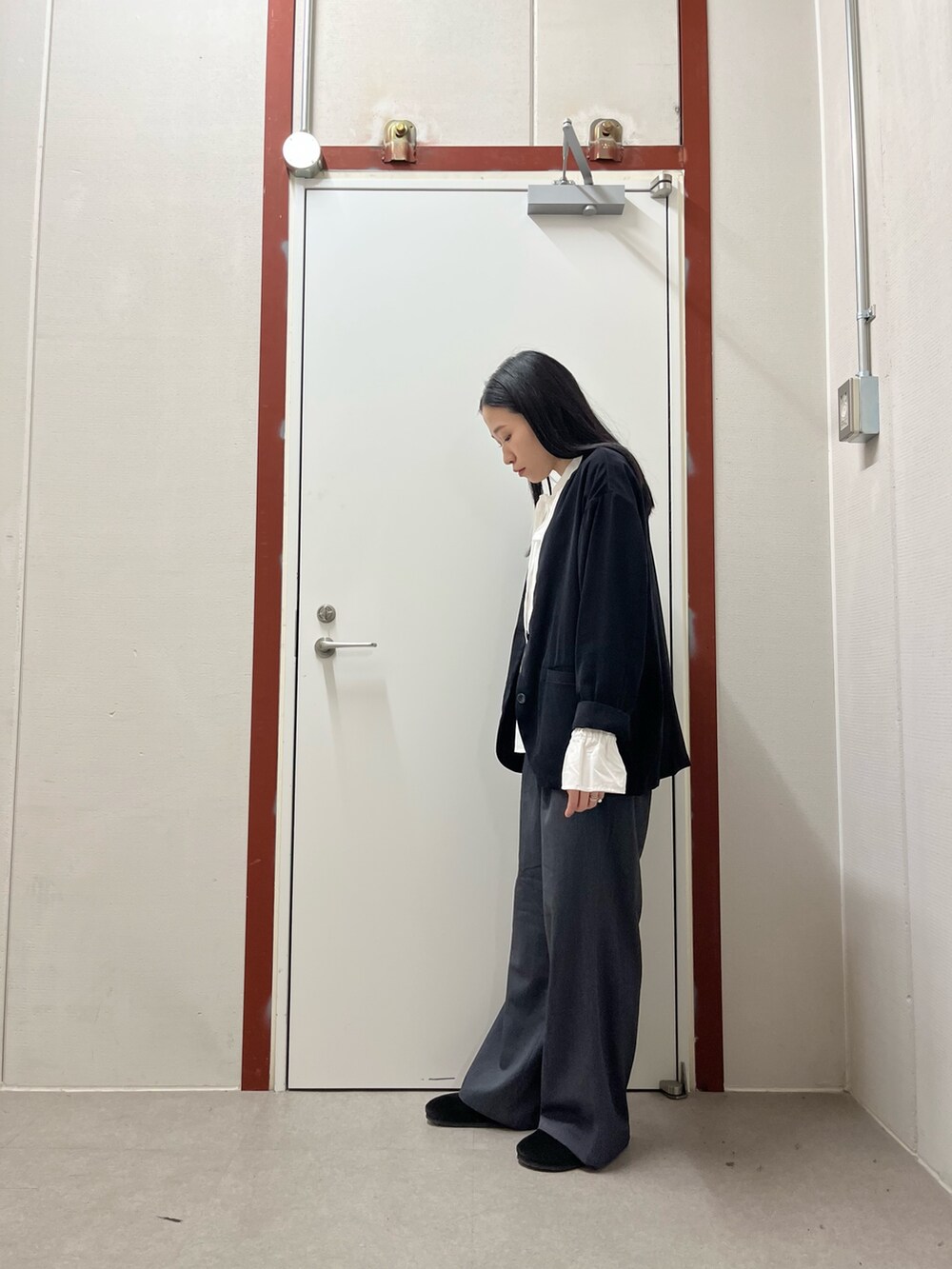 ブラック系のノーカラージャケット、ホワイト系のシャツ/ブラウス、グレー系のその他パンツを着用したレディースの秋コーディネートの2枚目の写真