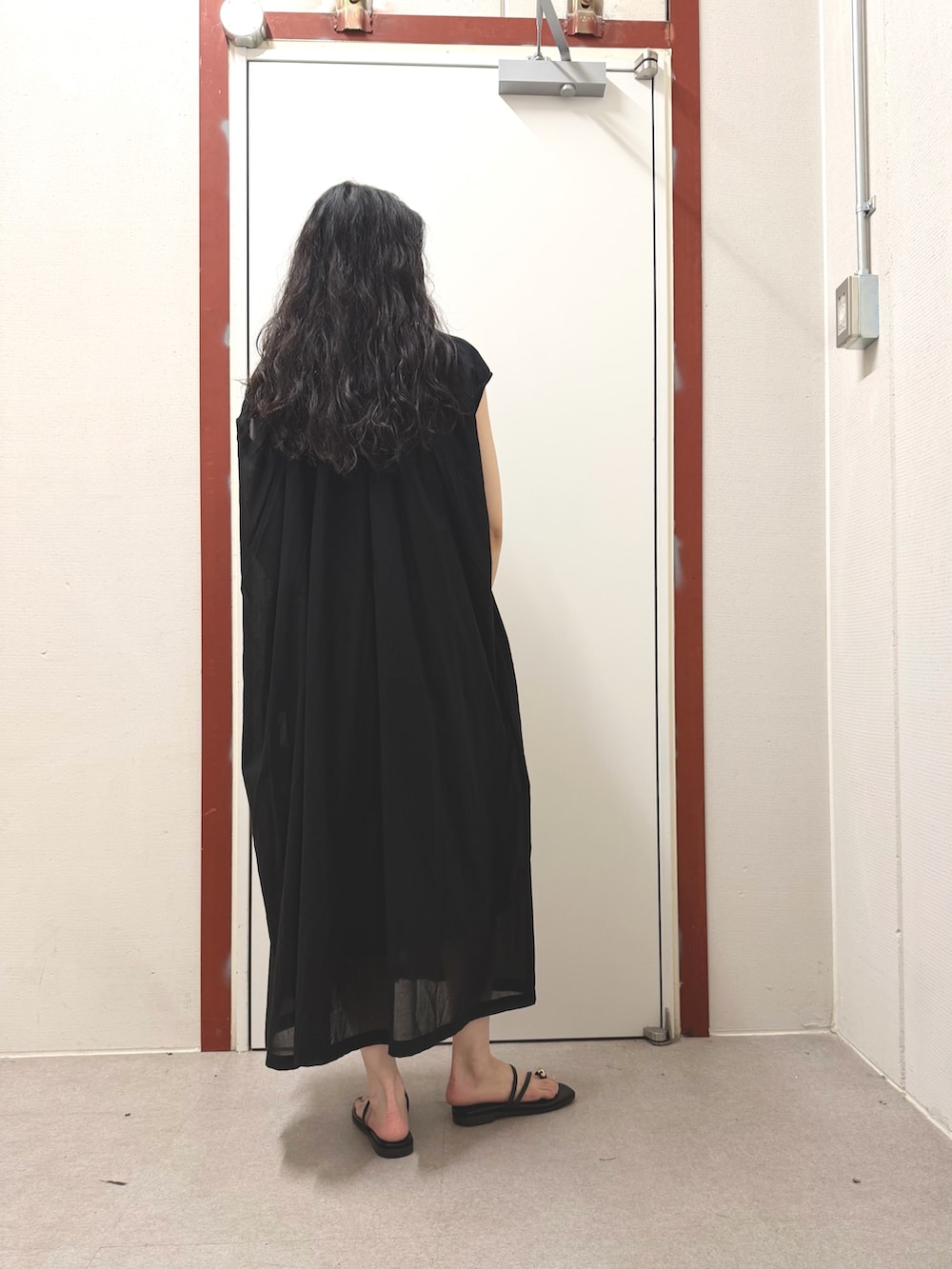 ブラック系のワンピース、ブラック系のサンダルを着用したレディースの夏コーディネートの3枚目の写真