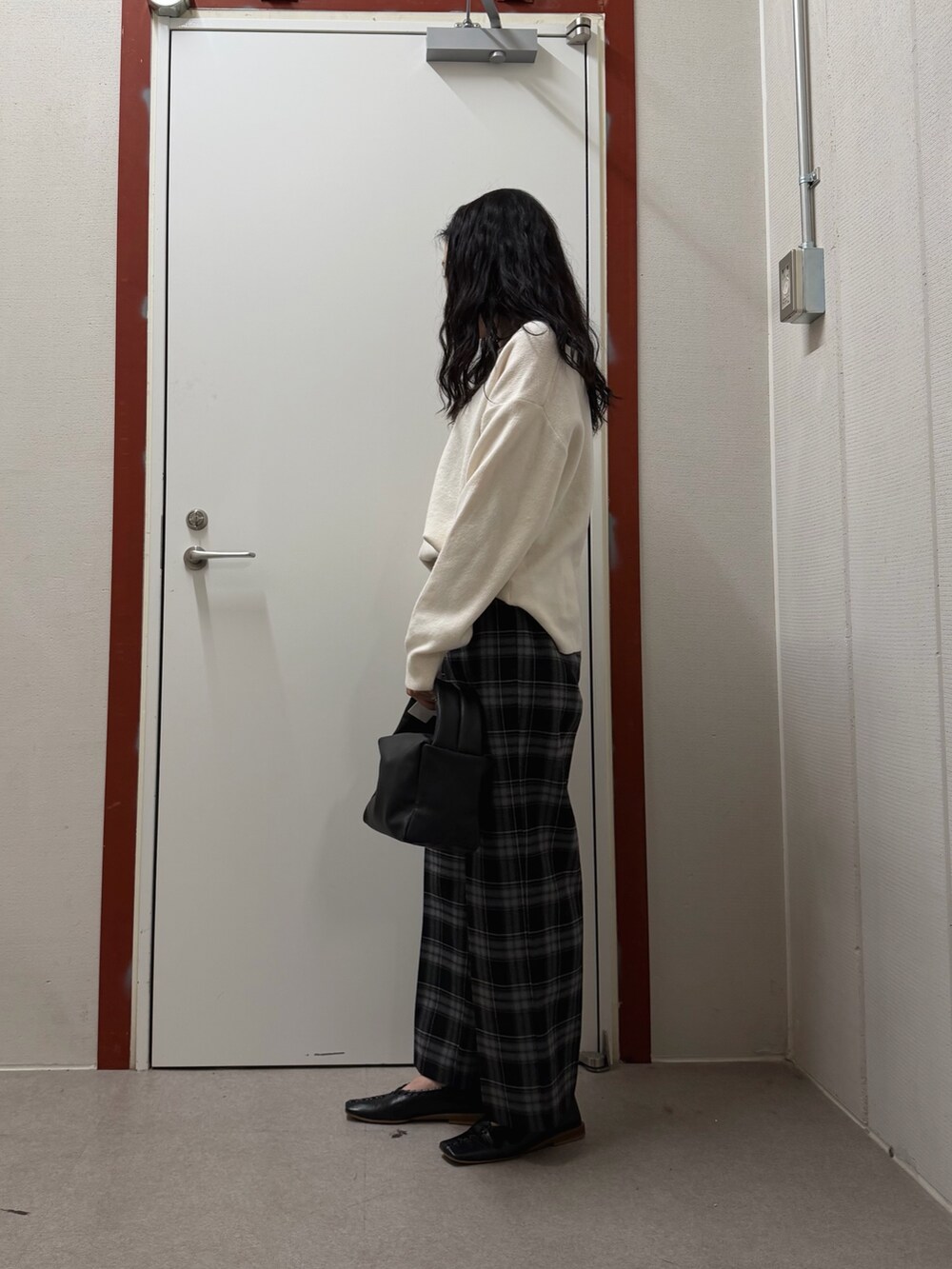 ホワイト系のニット/セーター、ブラック系のその他パンツ、ブラック系のハンドバッグを着用したレディースの冬コーディネートの2枚目の写真