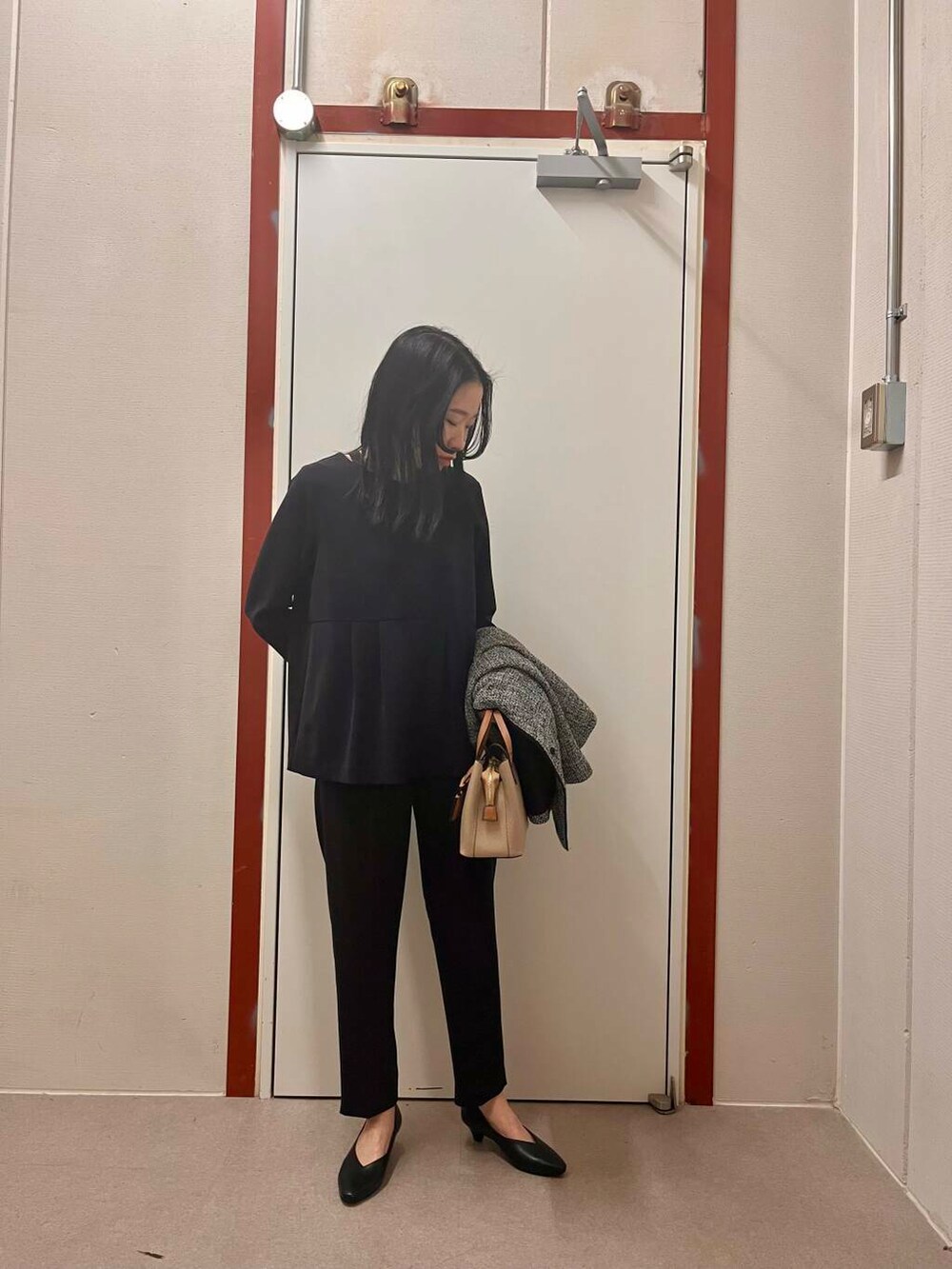 ベージュ系のトートバッグ、ブルー系のセットアップ、ブラック系のスーツジャケットを着用したレディースの冬コーディネートの2枚目の写真