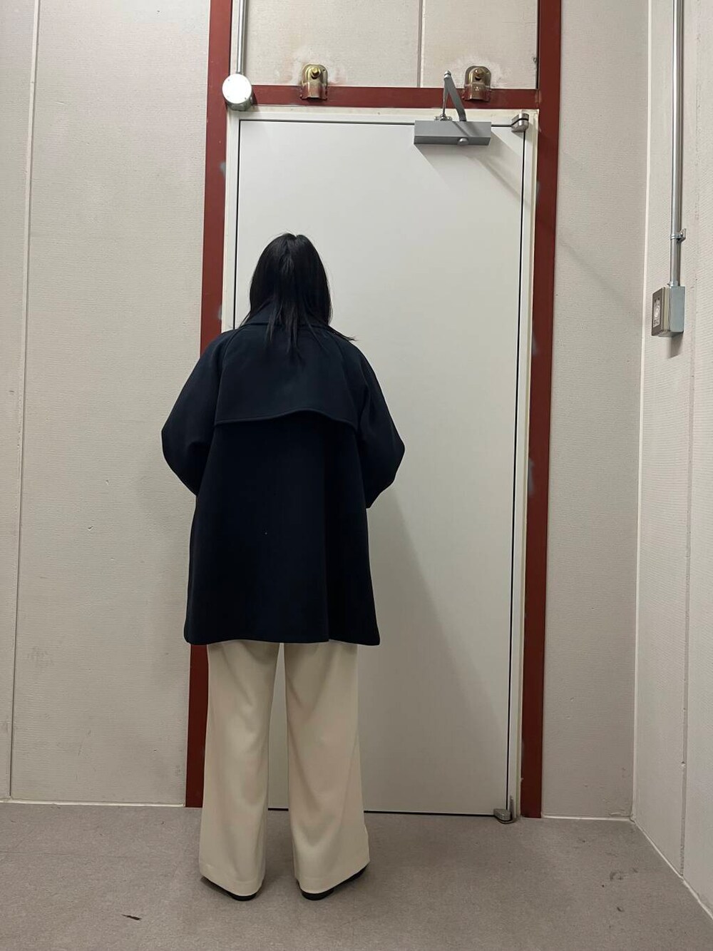 ブラック系のブーツ、レッド系のニット/セーター、ホワイト系のその他パンツを着用したレディースの冬コーディネートの4枚目の写真