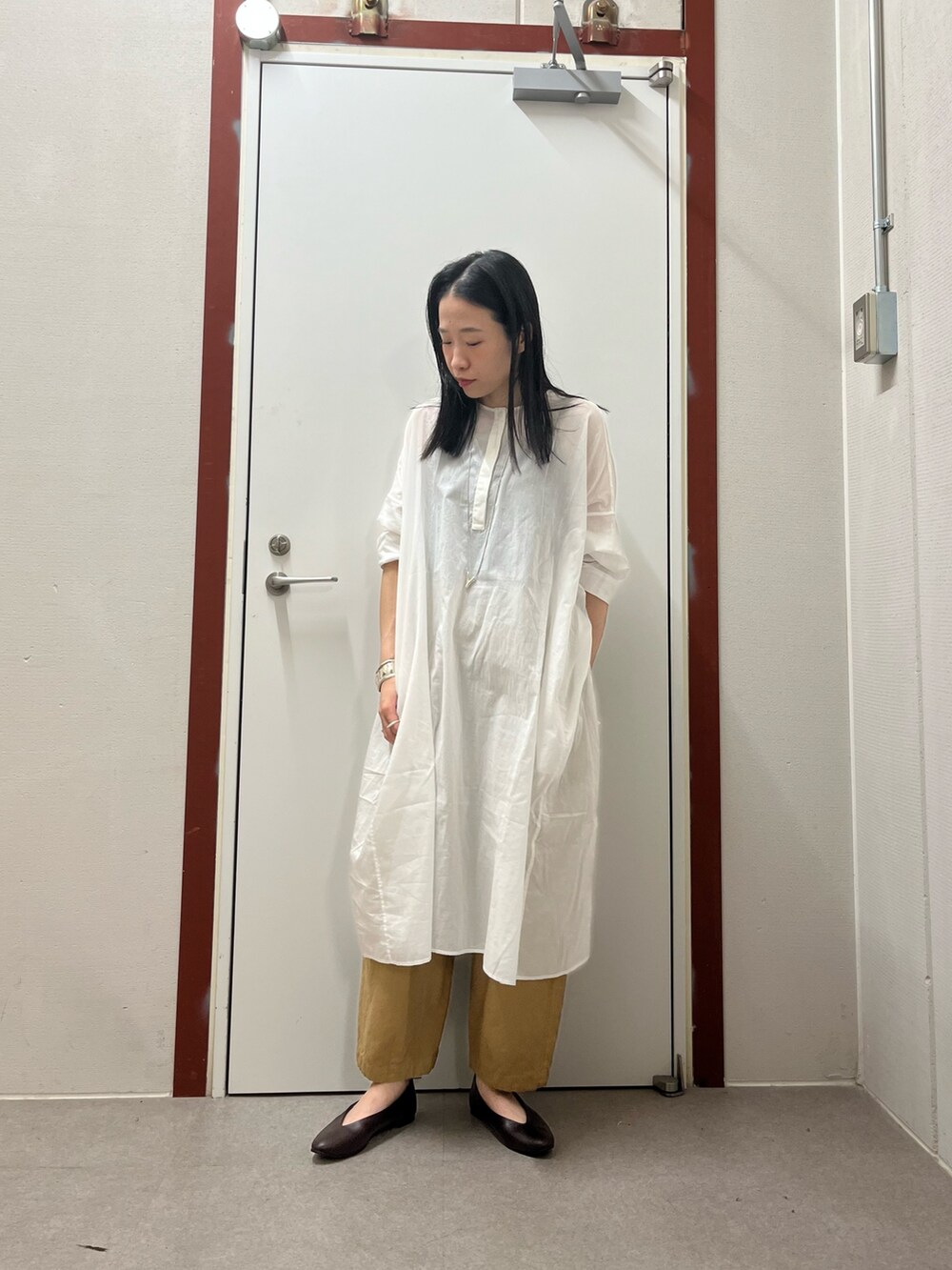 ブラウン系のパンプスを着用したレディースの夏コーディネートの2枚目の写真