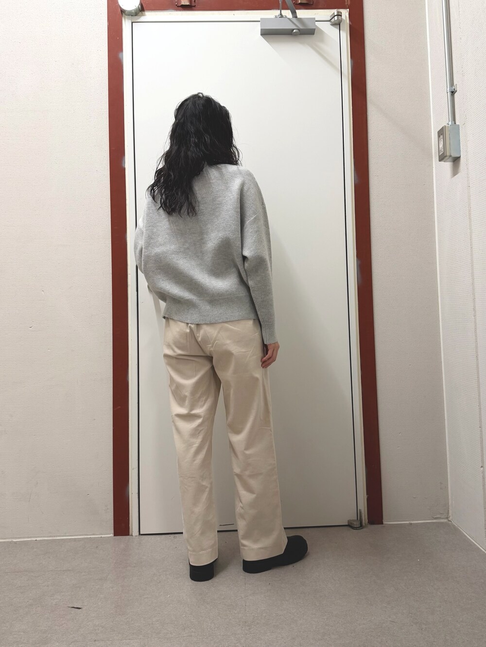 グレー系のニット/セーター、ホワイト系のその他パンツを着用したレディースの冬コーディネートの3枚目の写真