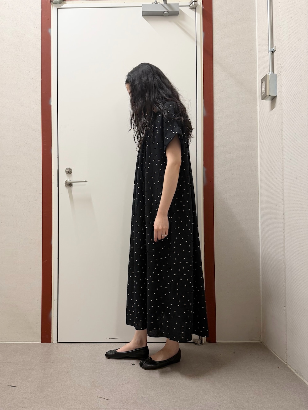 ブラック系のワンピース、ブラック系のバレエシューズを着用したレディースの春コーディネートの2枚目の写真