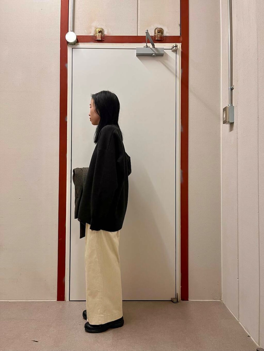 ブラック系のその他アウター、ホワイト系のその他パンツ、グレー系のニット/セーターを着用したレディースの冬コーディネートの3枚目の写真