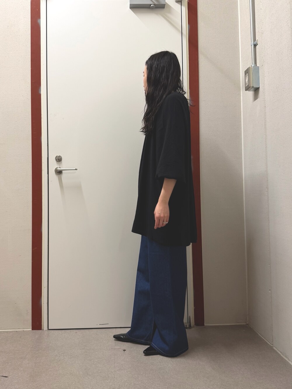 ブラック系のその他トップス、ブルー系のデニムパンツを着用したレディースの春コーディネートの2枚目の写真