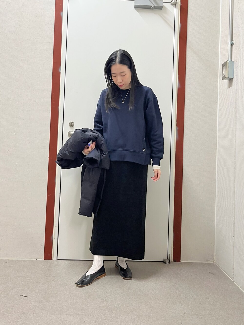 ブラック系のダウンジャケット/コート、ブルー系のスウェット、ブラック系のスカートを着用したレディースの秋コーディネートの3枚目の写真