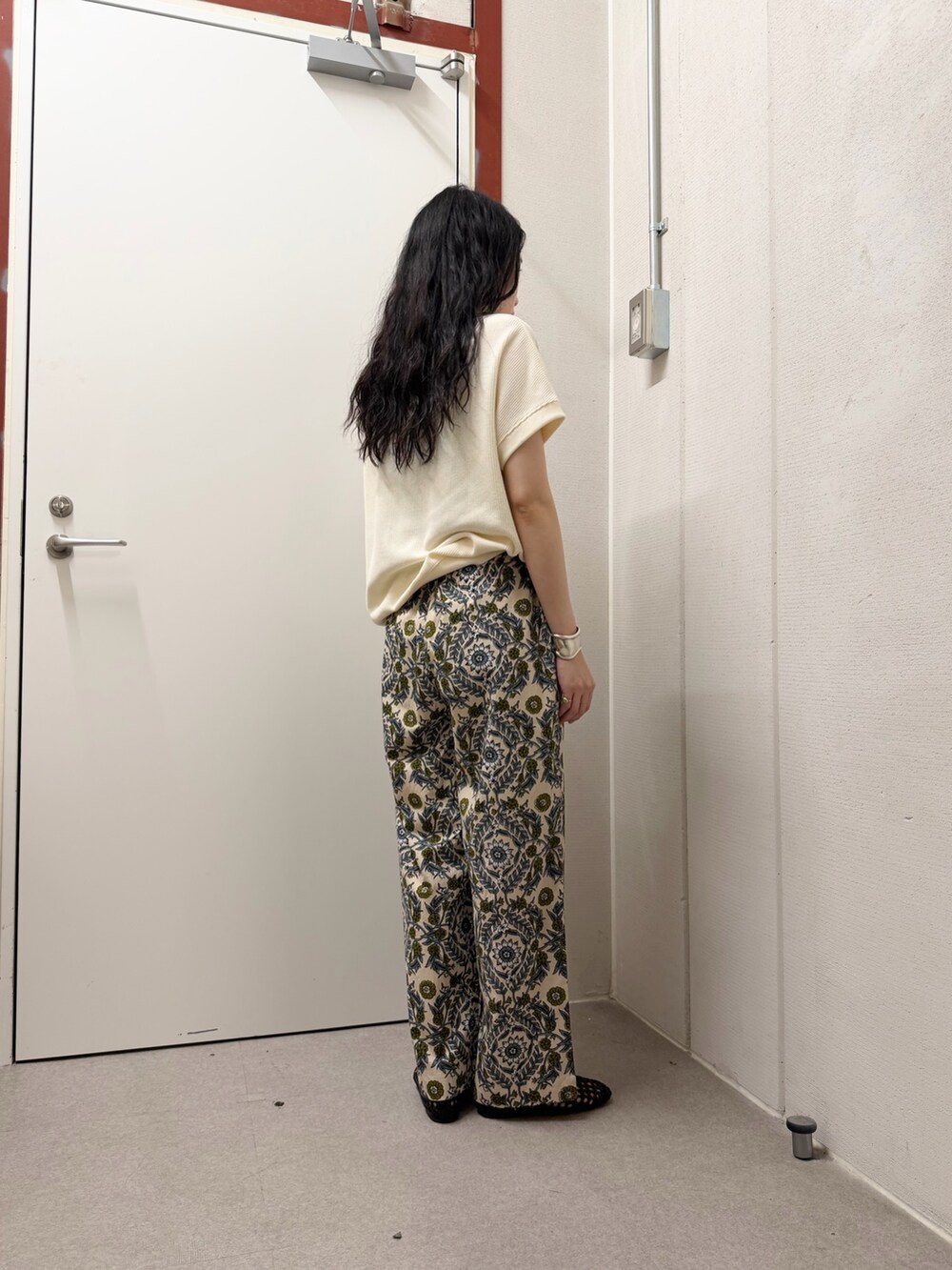 ベージュ系のTシャツ/カットソー、ベージュ系のその他パンツ、ブラック系のサンダルを着用したレディースの春コーディネートの3枚目の写真