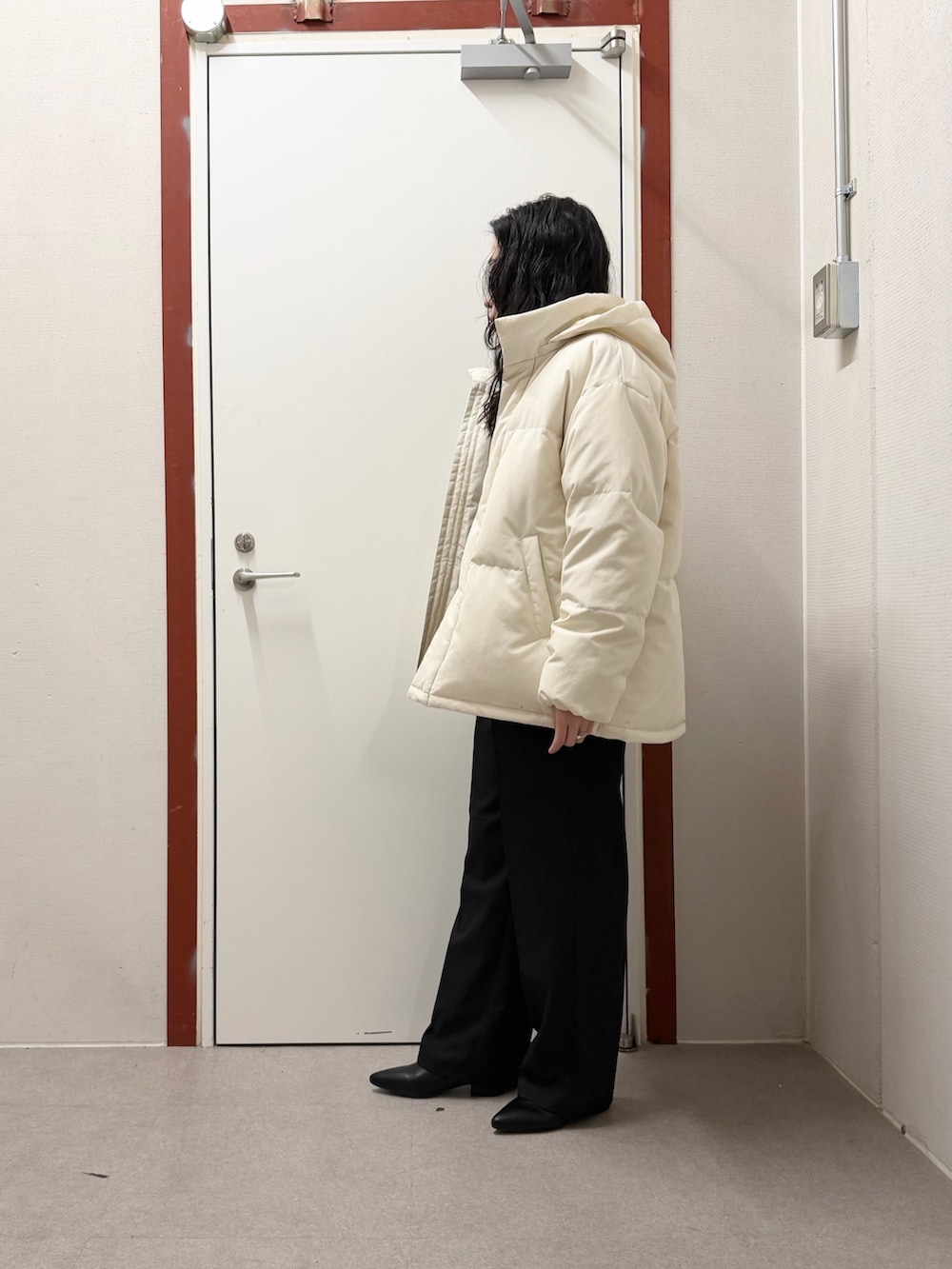 ホワイト系のダウンジャケット/コート、グリーン系のニット/セーター、ブラック系のその他パンツを着用したレディースの冬コーディネートの2枚目の写真