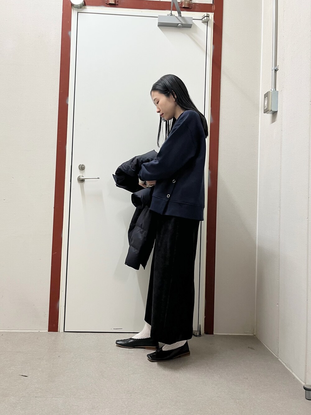 ブラック系のダウンジャケット/コート、ブルー系のスウェット、ブラック系のスカートを着用したレディースの秋コーディネートの4枚目の写真