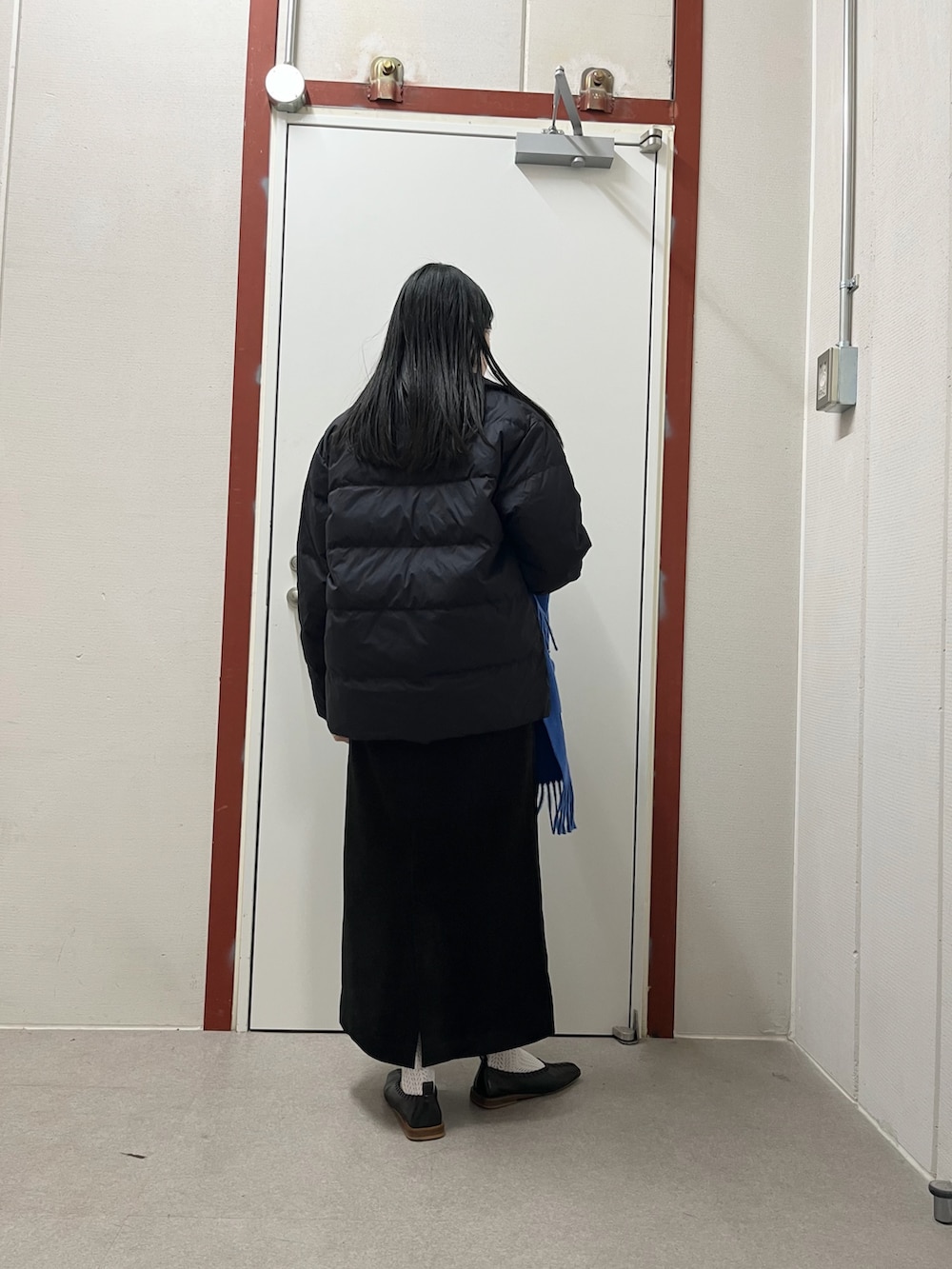 ブラック系のダウンジャケット/コート、ブルー系のスウェット、ブラック系のスカートを着用したレディースの秋コーディネートの2枚目の写真