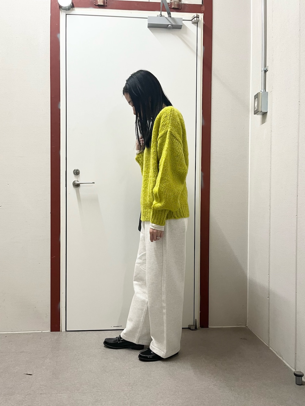 イエロー系のニット/セーター、ベージュ系のその他パンツ、ブラック系のローファーを着用したレディースの秋コーディネートの2枚目の写真