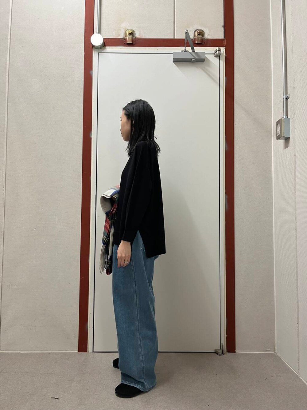 ブラック系のニット/セーター、ブラック系のサンダル、ホワイト系のストール/ショールを着用したレディースの秋コーディネートの4枚目の写真