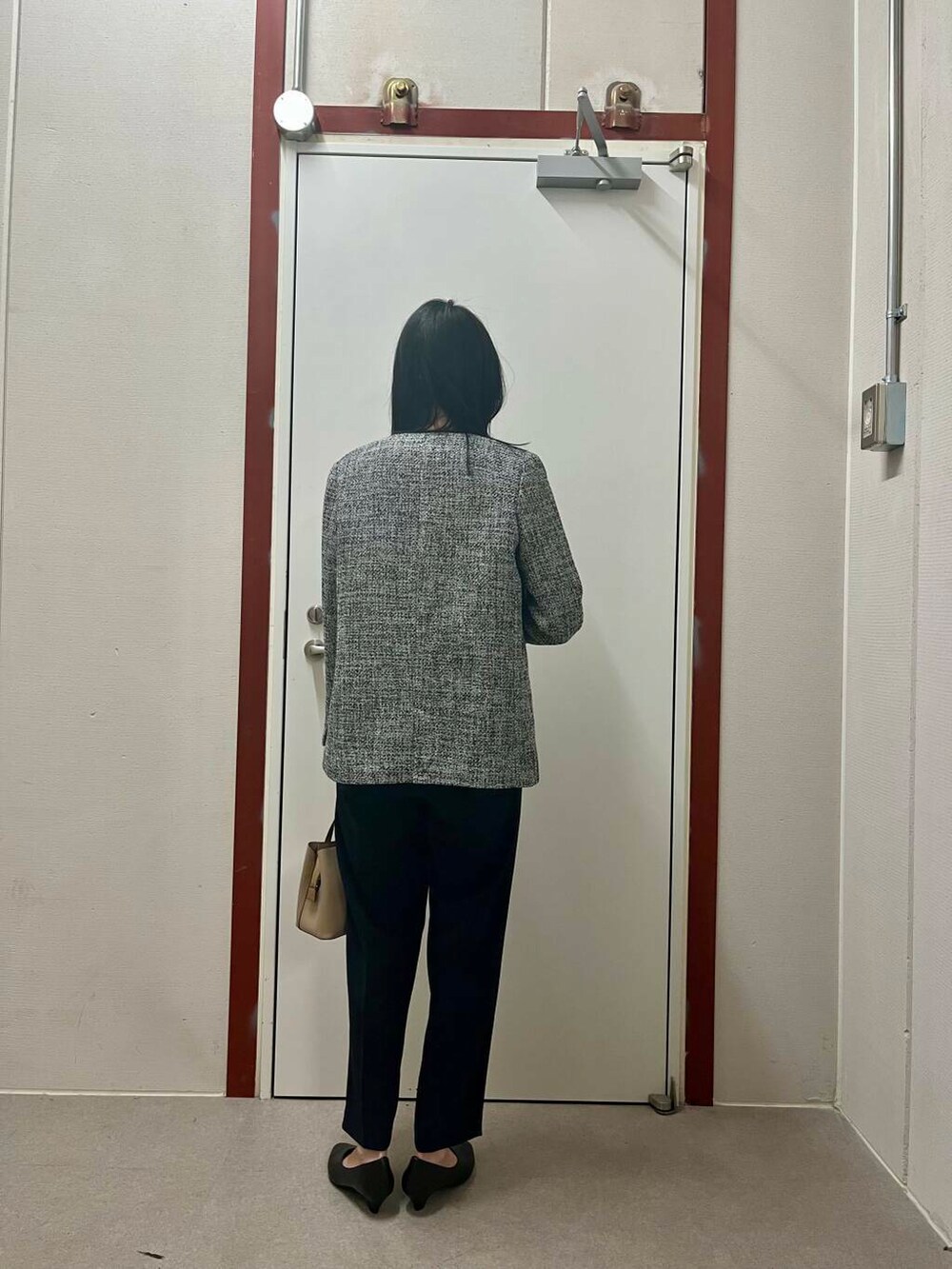 ベージュ系のトートバッグ、ブルー系のセットアップ、ブラック系のスーツジャケットを着用したレディースの冬コーディネートの4枚目の写真