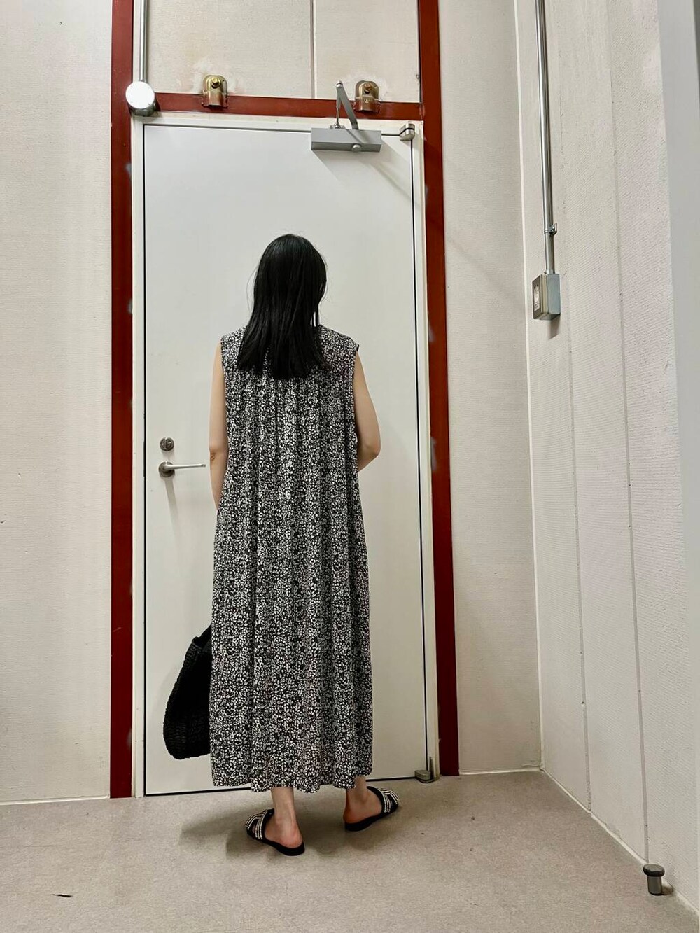 ブラック系のサンダル、ブラック系のワンピースを着用したレディースの夏コーディネートの3枚目の写真