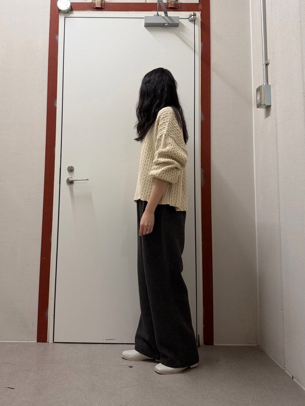 ベージュ系のニット/セーター、グレー系のその他パンツ、ホワイト系のブーツを着用したレディースの冬コーディネートの2枚目の写真