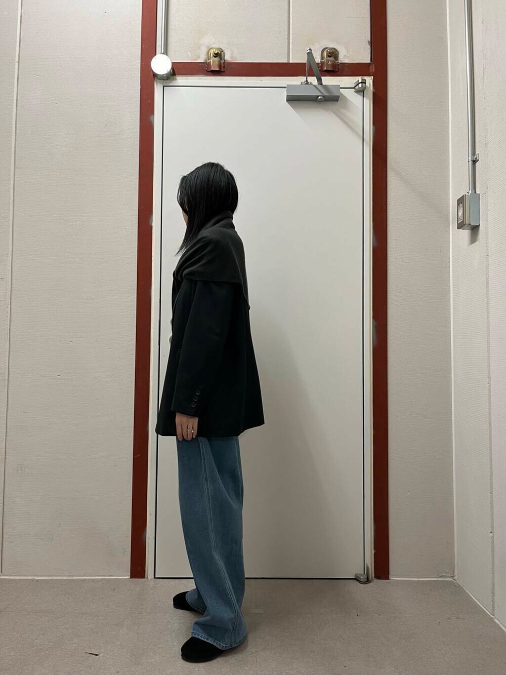 ブラック系のその他アウター、グリーン系のニット/セーター、ブラック系のサンダルを着用したレディースの秋コーディネートの2枚目の写真