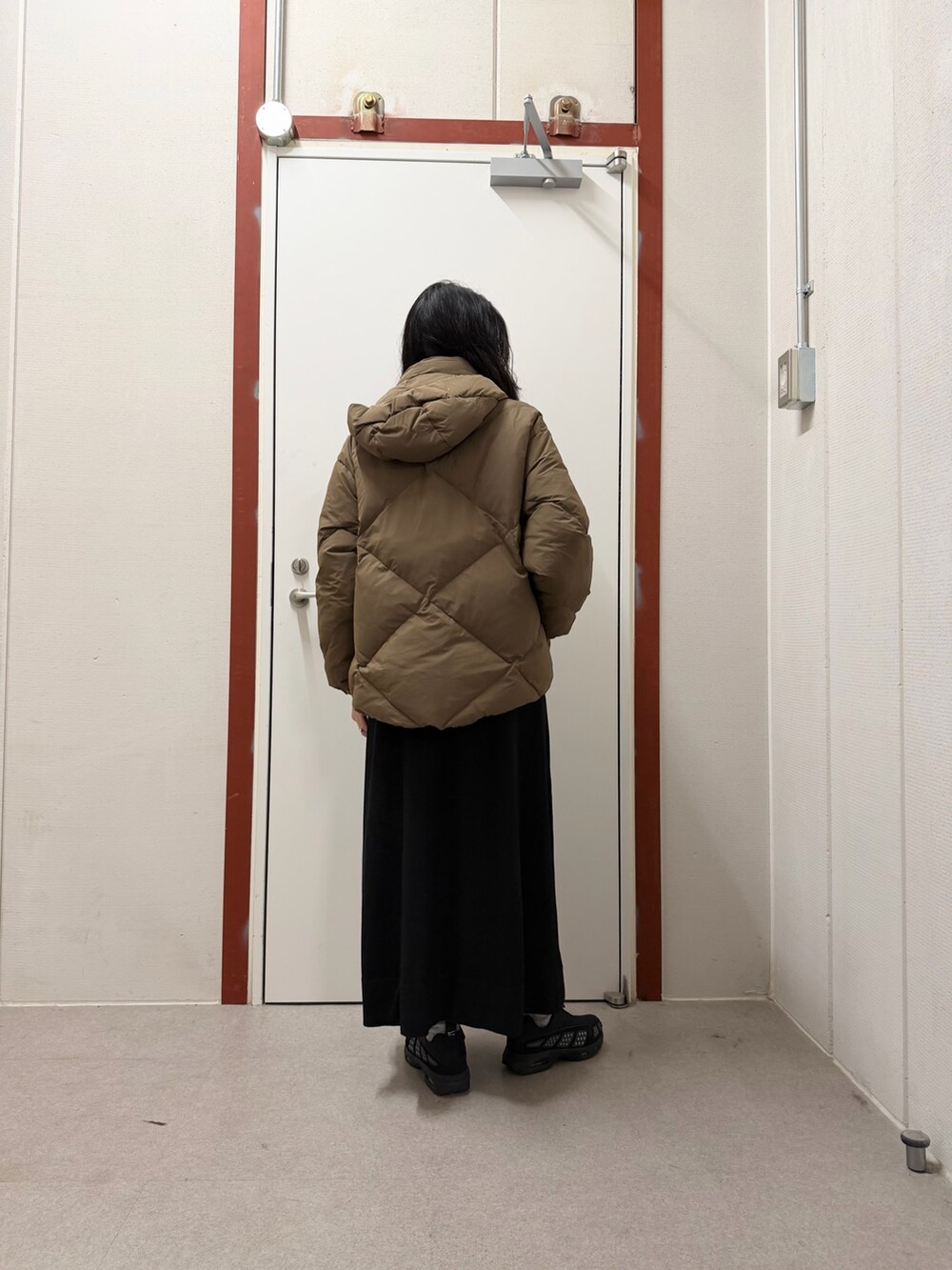 ブラウン系のダウンジャケット/コート、ブラック系のワンピースを着用したレディースの秋コーディネートの3枚目の写真