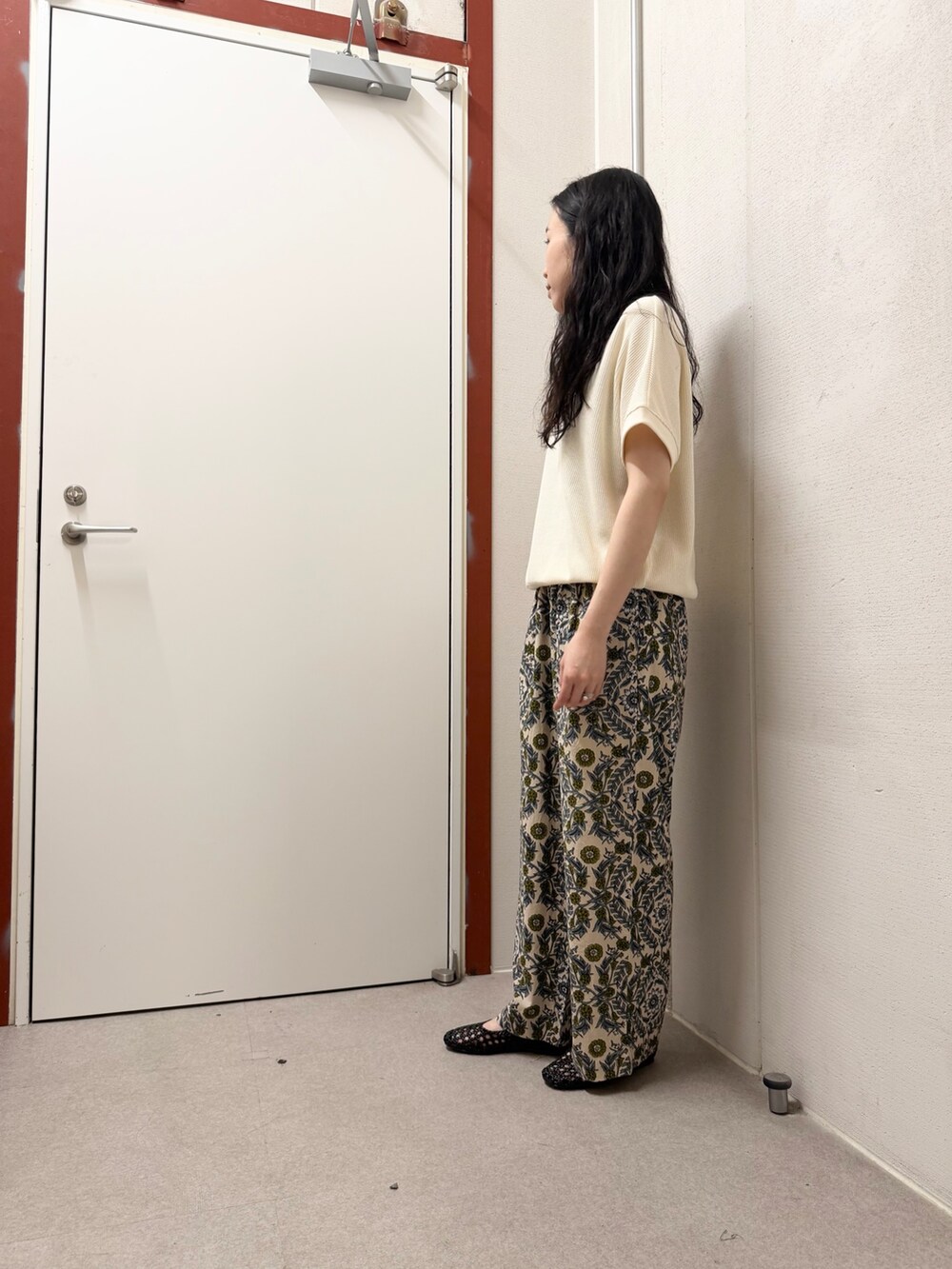 ベージュ系のTシャツ/カットソー、ベージュ系のその他パンツ、ブラック系のサンダルを着用したレディースの春コーディネートの2枚目の写真