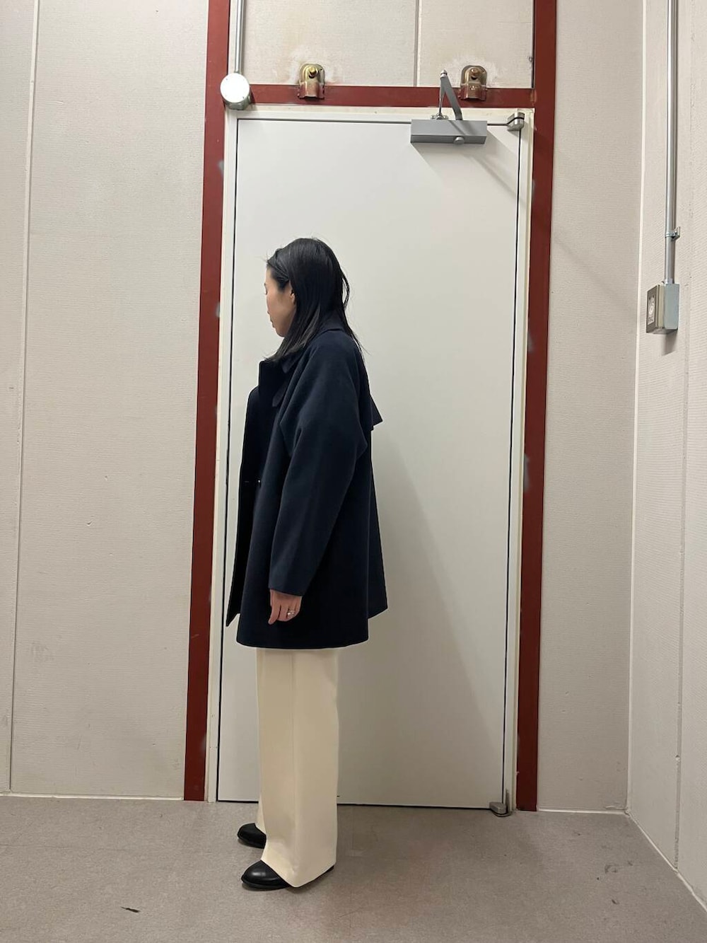 ブラック系のブーツ、レッド系のニット/セーター、ホワイト系のその他パンツを着用したレディースの冬コーディネートの3枚目の写真