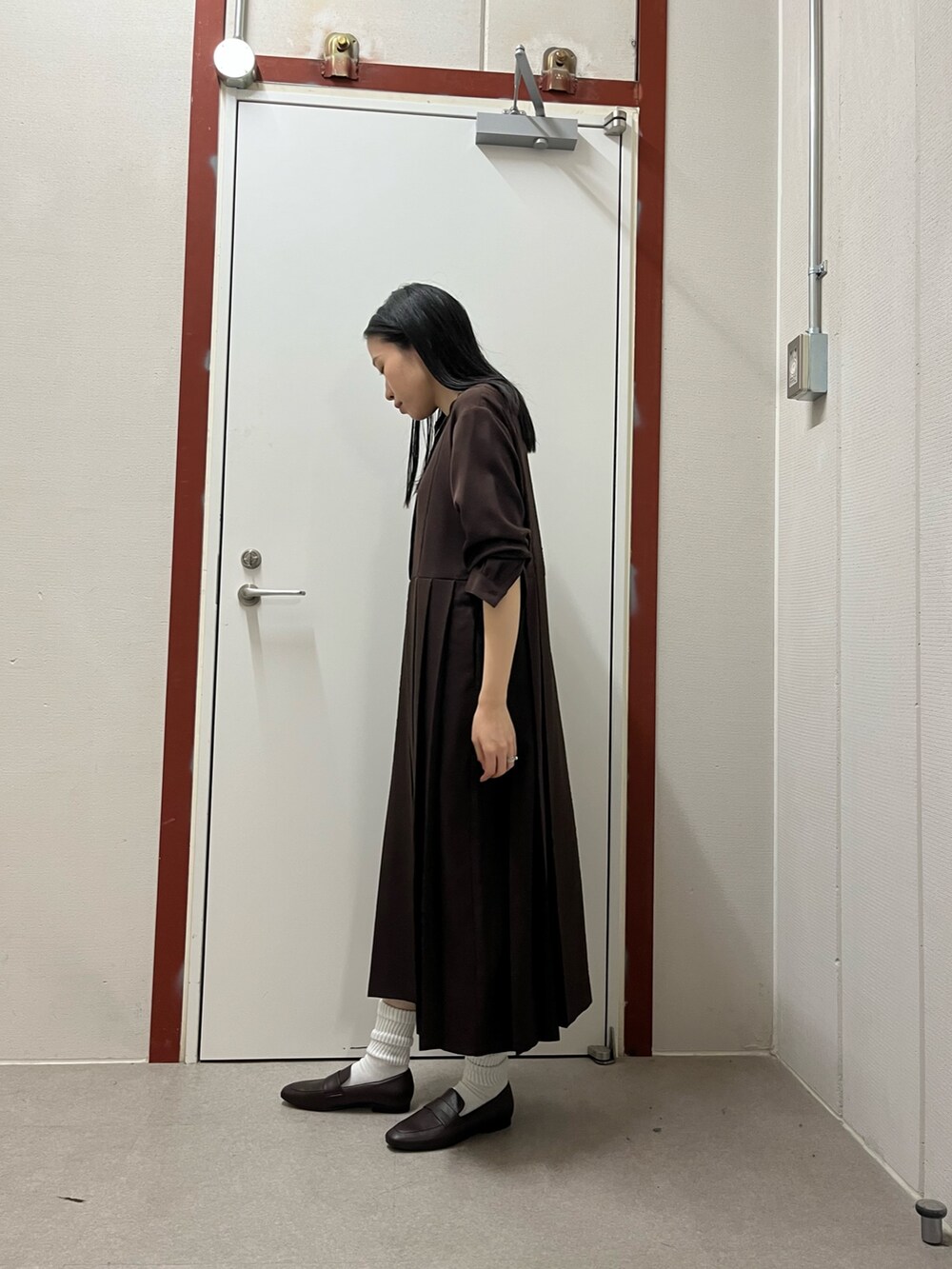 ブラウン系のワンピースを着用したレディースの秋コーディネートの2枚目の写真