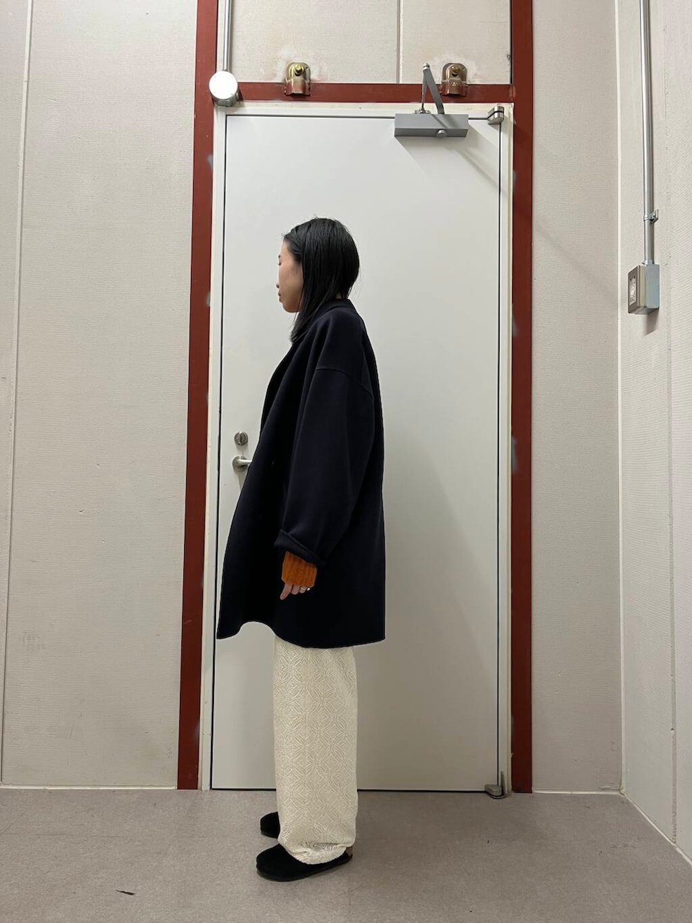 ブルー系のその他アウター、オレンジ系のニット/セーター、ブラック系のサンダルを着用したレディースの秋コーディネートの2枚目の写真