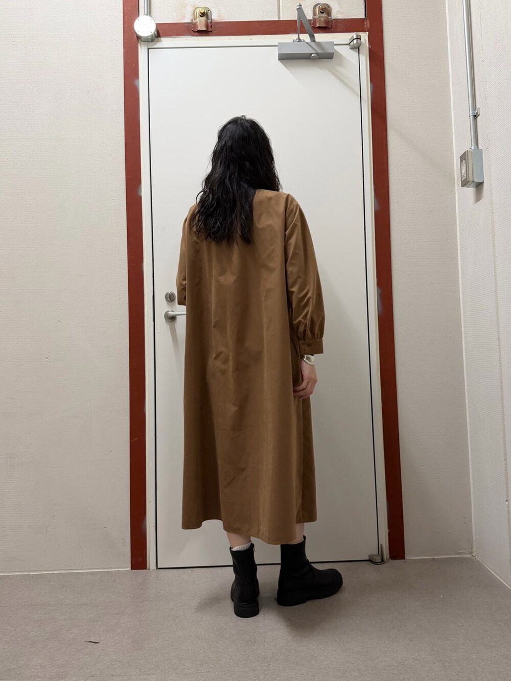 イエロー系のワンピースを着用したレディースの冬コーディネートの3枚目の写真