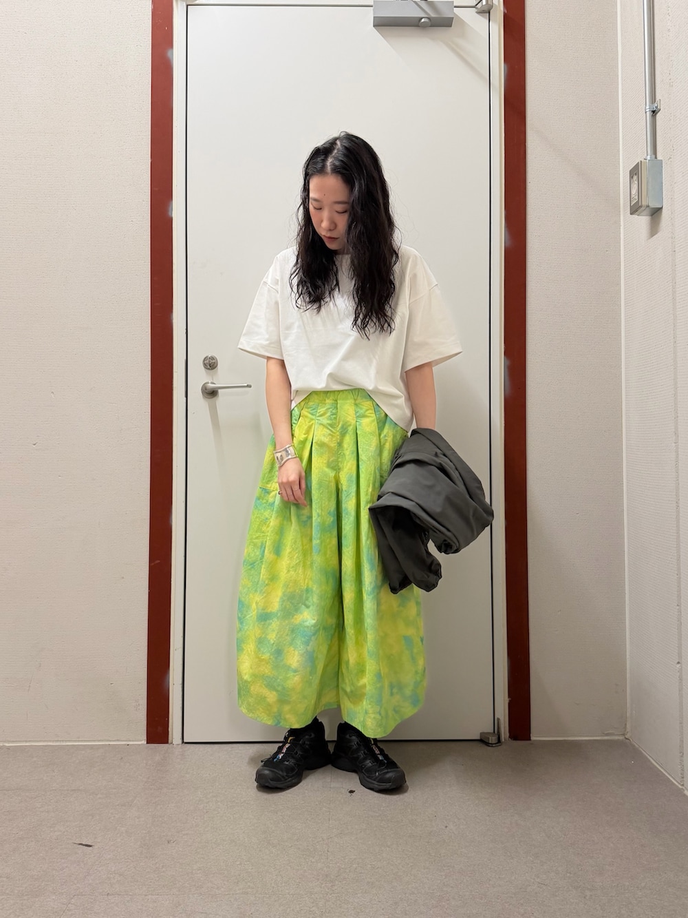 グレー系のナイロンジャケット、ホワイト系のTシャツ/カットソー、グリーン系のその他パンツを着用したレディースの春コーディネートの2枚目の写真