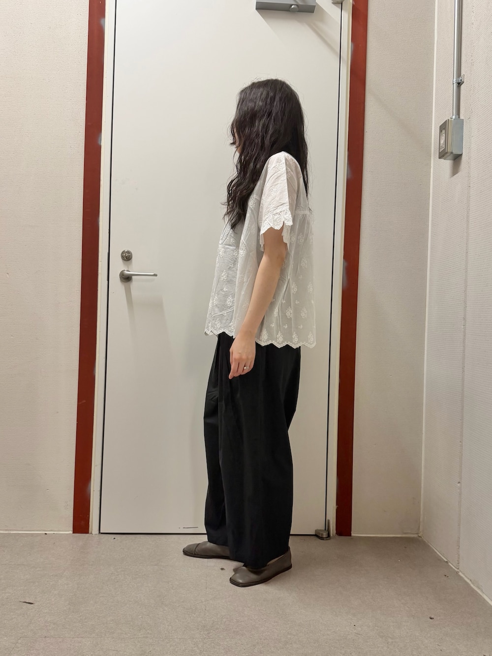 ホワイト系のシャツ/ブラウス、ブラック系のその他パンツ、ベージュ系のハンドバッグを着用したレディースの夏コーディネートの2枚目の写真