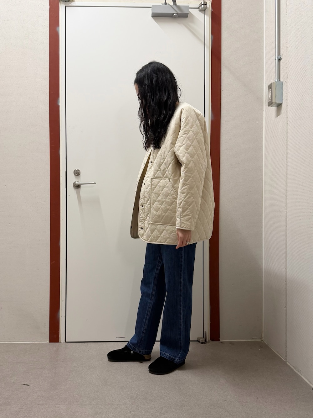 ホワイト系のダウンジャケット/コート、ブルー系のデニムパンツ、ホワイト系のTシャツ/カットソーを着用したレディースの冬コーディネートの2枚目の写真