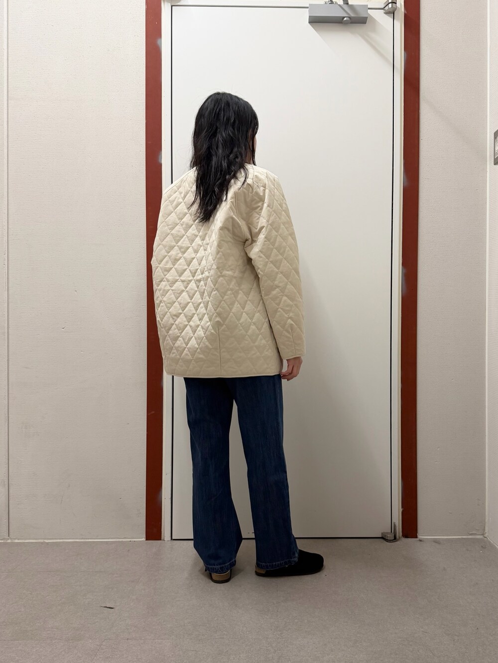 ホワイト系のダウンジャケット/コート、ブルー系のデニムパンツ、ホワイト系のTシャツ/カットソーを着用したレディースの冬コーディネートの3枚目の写真