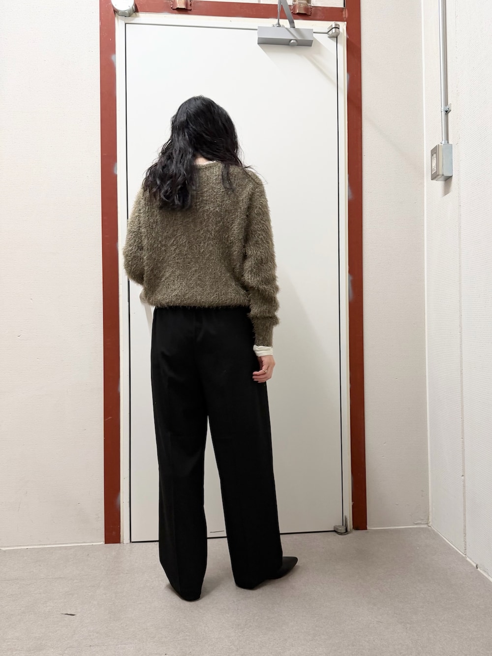 ホワイト系のダウンジャケット/コート、グリーン系のニット/セーター、ブラック系のその他パンツを着用したレディースの冬コーディネートの6枚目の写真