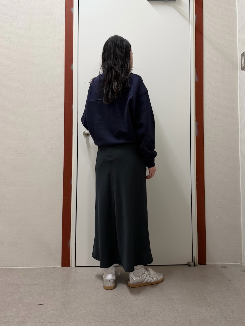 ブルー系のスウェット、ブルー系のスカート、シルバー系のスニーカーを着用したレディースの冬コーディネートの3枚目の写真