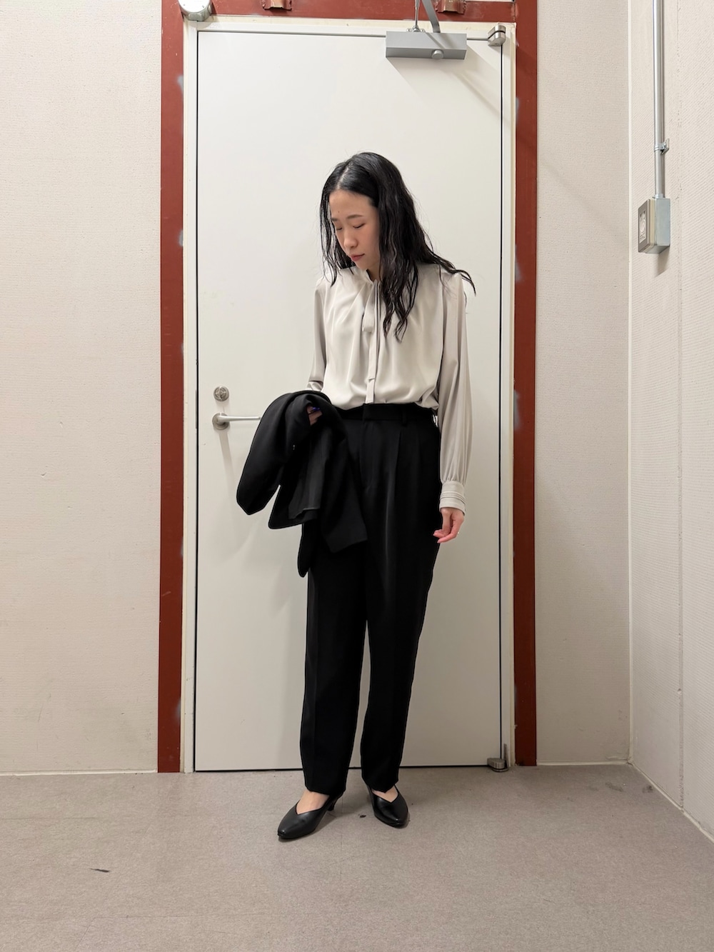 ブラック系のスーツジャケット、ブラック系のその他パンツ、ブラック系のパンプスを着用したレディースの冬コーディネートの4枚目の写真