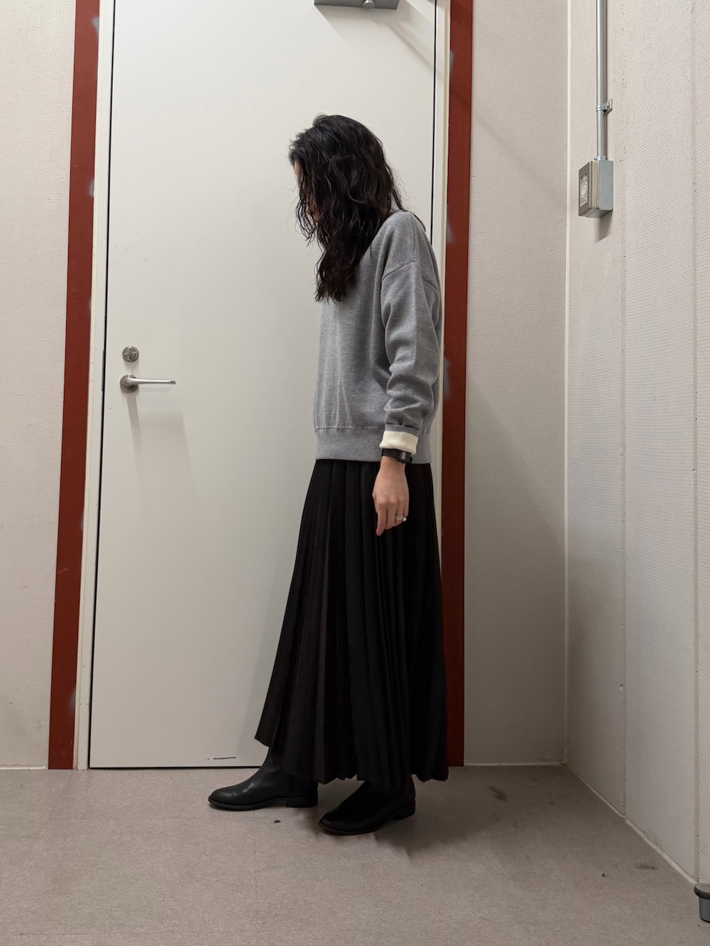 グレー系のニット/セーター、ブラック系のスカートを着用したレディースの冬コーディネートの2枚目の写真