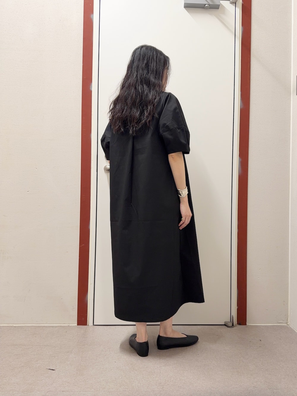 ブラック系のワンピース、ブラック系のパンプスを着用したレディースの春コーディネートの3枚目の写真