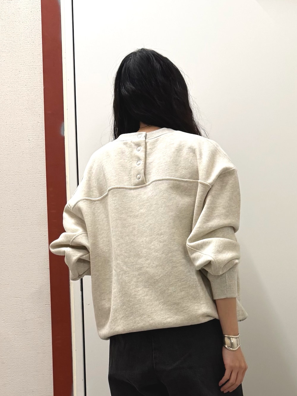 ベージュ系のスウェット、ブラック系のデニムパンツを着用したレディースの冬コーディネートの3枚目の写真