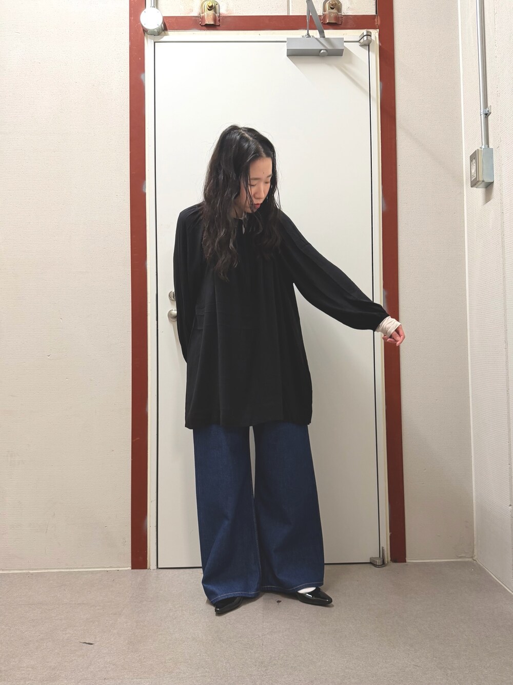 ブラック系のその他トップス、ブルー系のデニムパンツを着用したレディースの春コーディネートの4枚目の写真