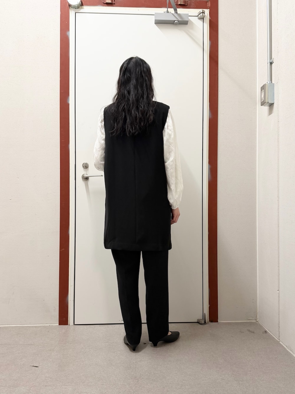 ブラック系のその他パンツ、ブラック系のベスト、ホワイト系のシャツ/ブラウスを着用したレディースの冬コーディネートの3枚目の写真