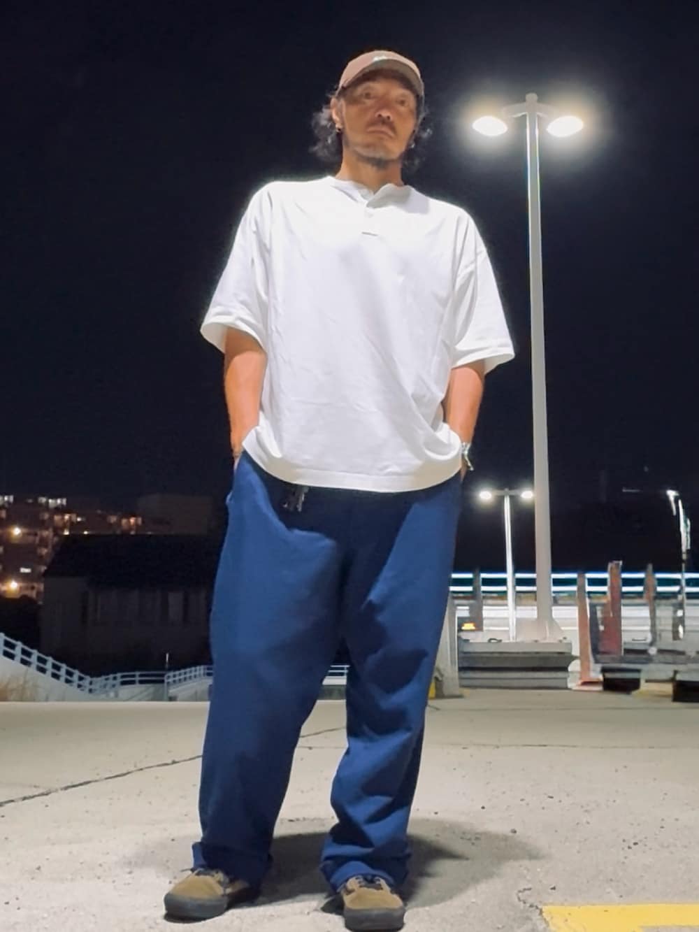 ホワイト系のTシャツ/カットソー、ブラウン系のスニーカー、ブルー系のパンツを着用したメンズの夏コーディネートの2枚目の写真