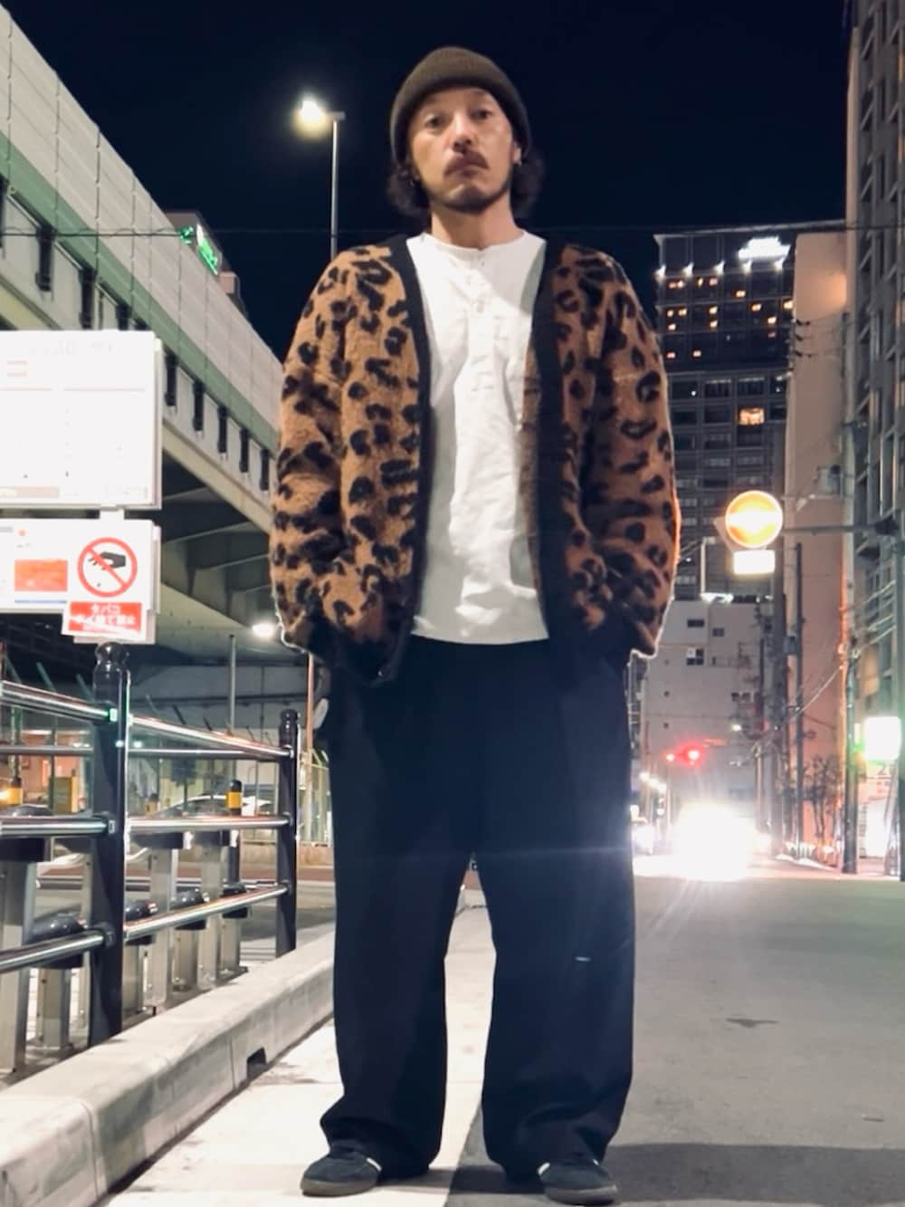 ブラック系のスニーカー、ブラック系のスラックス、ブラウン系のカーディガン/ボレロを着用したメンズの春コーディネートの2枚目の写真