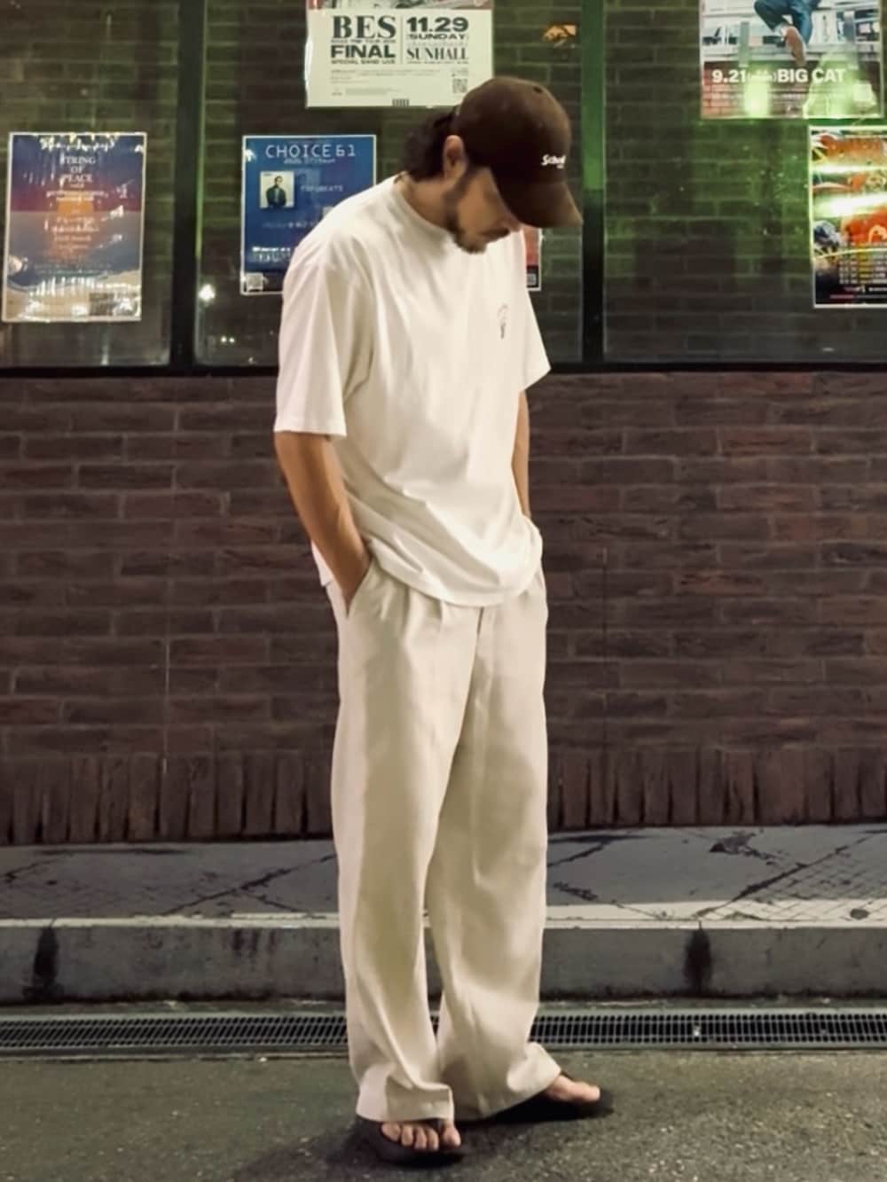 ホワイト系のTシャツ/カットソー、ホワイト系のスラックス、ブラック系のサンダルを着用したメンズの夏コーディネートの2枚目の写真