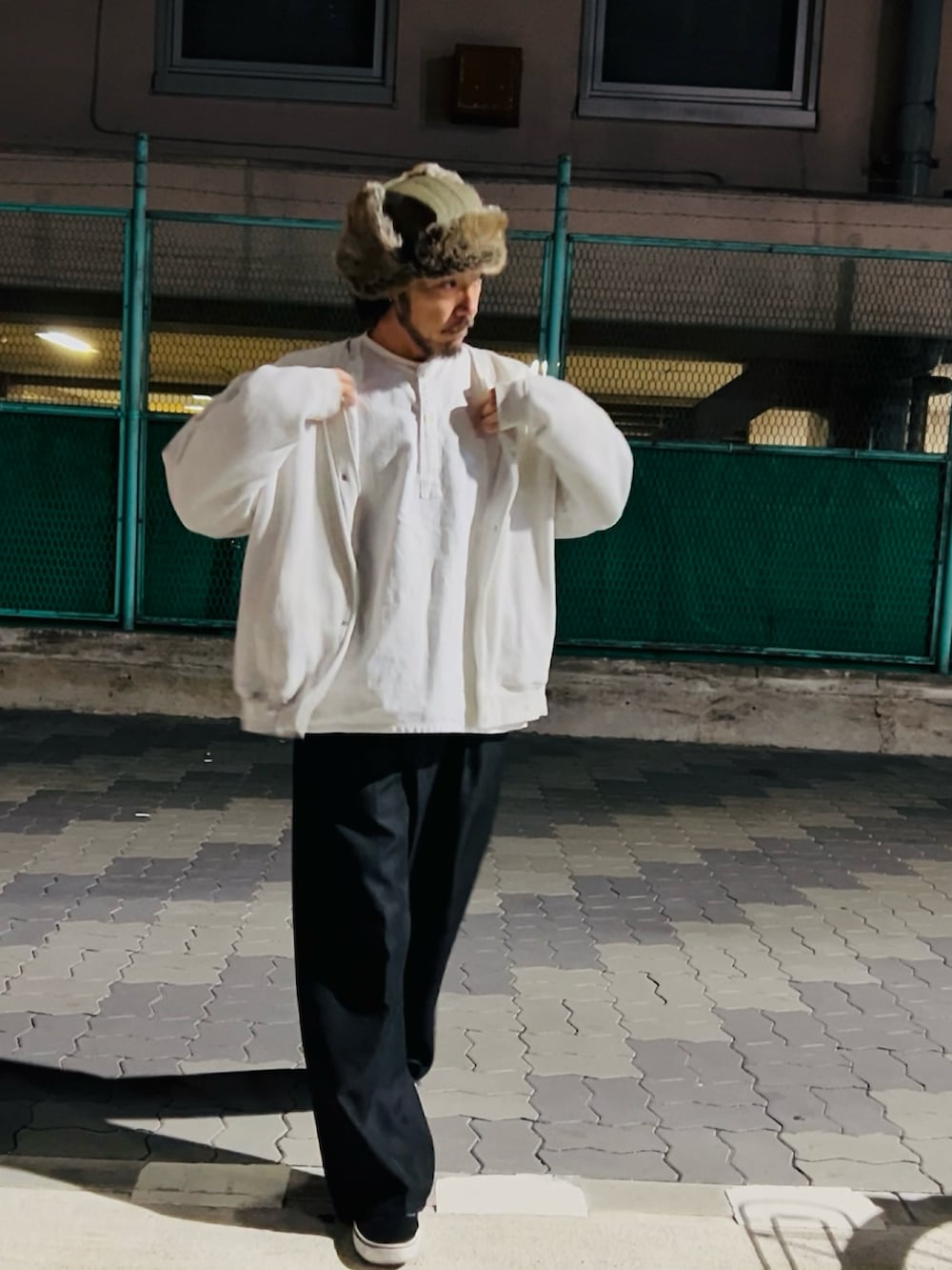 グレー系のカーディガン/ボレロ、ホワイト系のシャツ/ブラウス、ブラック系のパンツを着用したメンズの冬コーディネートの2枚目の写真