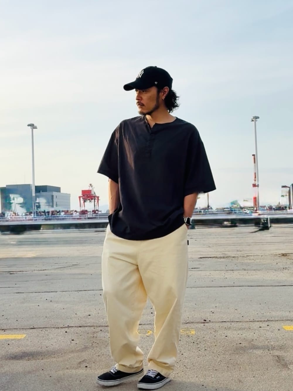 ブラック系のTシャツ/カットソー、ベージュ系のその他パンツ、ブラック系のスニーカーを着用したメンズの春コーディネートの2枚目の写真