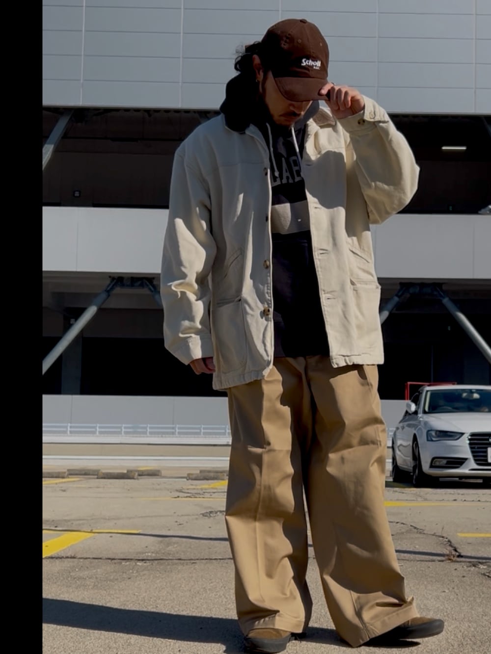 ホワイト系のデニムジャケット、ベージュ系のチノパンツ、ブラック系のスニーカーを着用したメンズの冬コーディネートの2枚目の写真