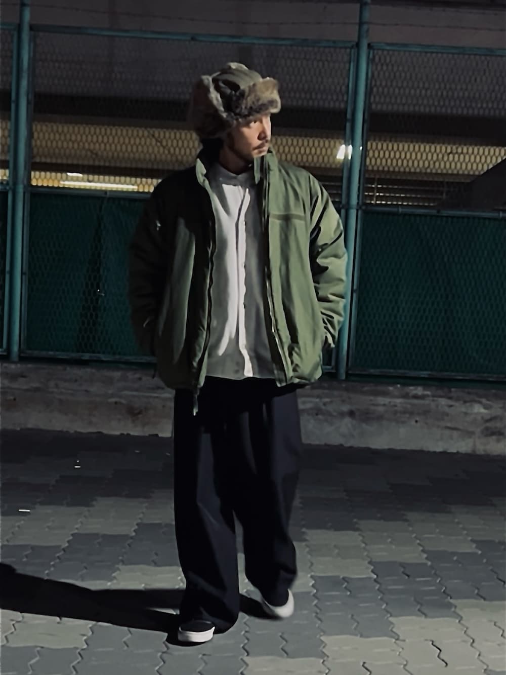 グレー系のカーディガン/ボレロ、ホワイト系のシャツ/ブラウス、ブラック系のパンツを着用したメンズの冬コーディネートの3枚目の写真