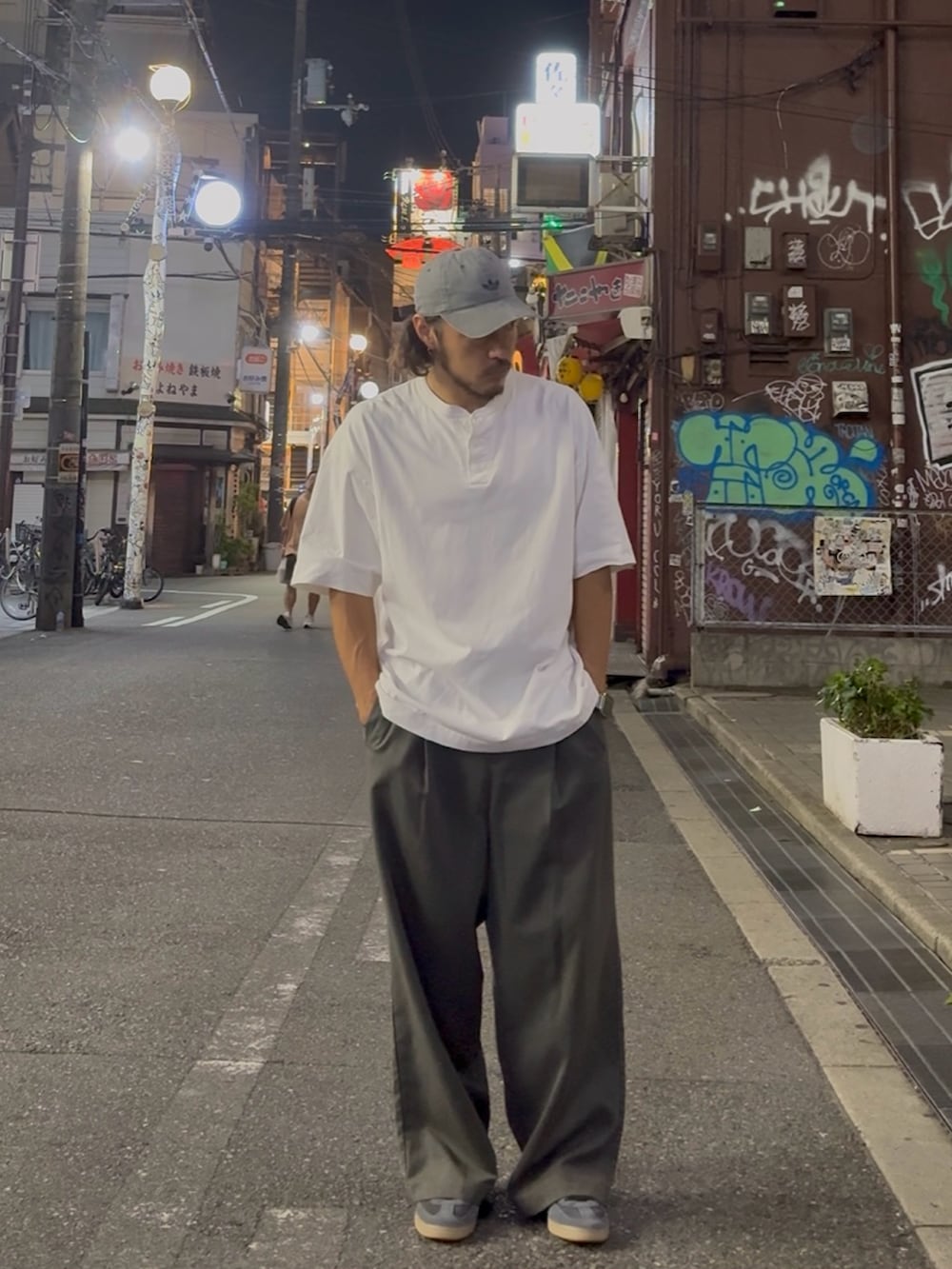 ホワイト系のTシャツ/カットソー、グレー系のスニーカー、グレー系のスラックスを着用したメンズの夏コーディネートの2枚目の写真