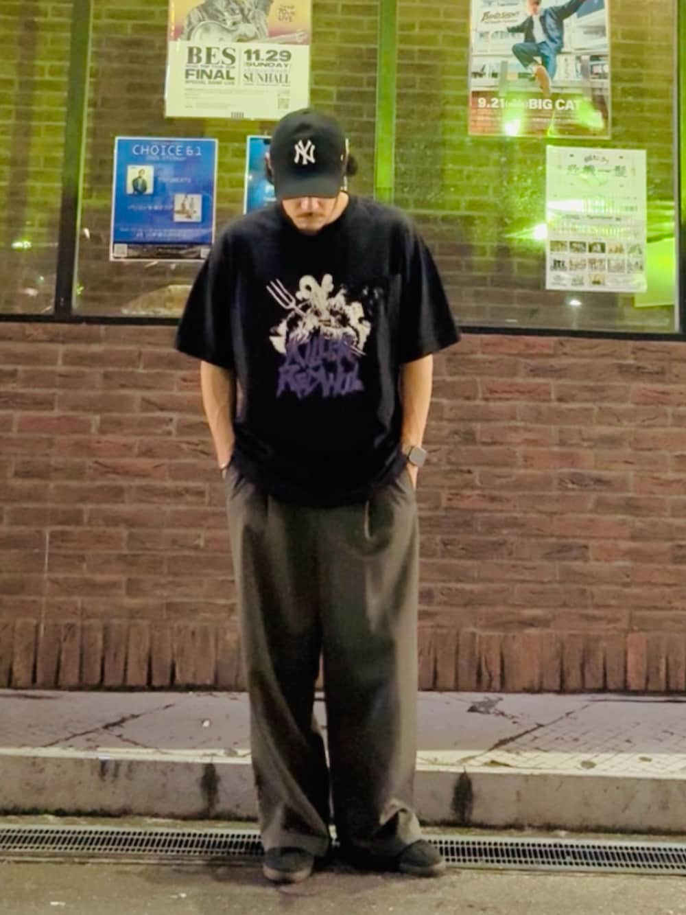 ブラック系のTシャツ/カットソー、グレー系のスラックス、ブラック系のスニーカーを着用したメンズの夏コーディネートの2枚目の写真