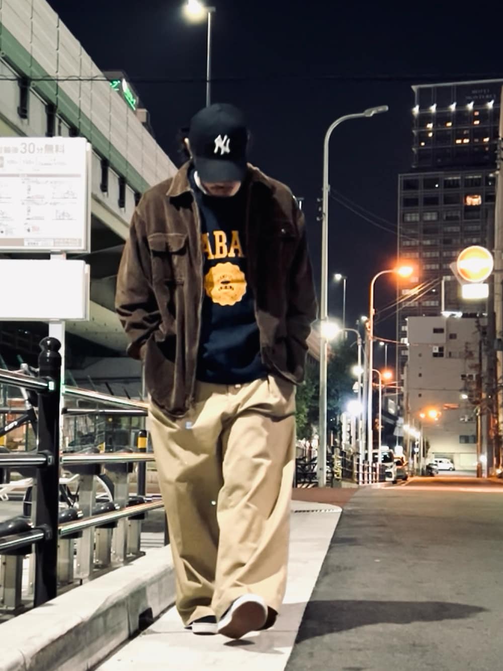 ブルー系のニット/セーター、ベージュ系のチノパンツ、ブラック系のスニーカーを着用したメンズの冬コーディネートの2枚目の写真
