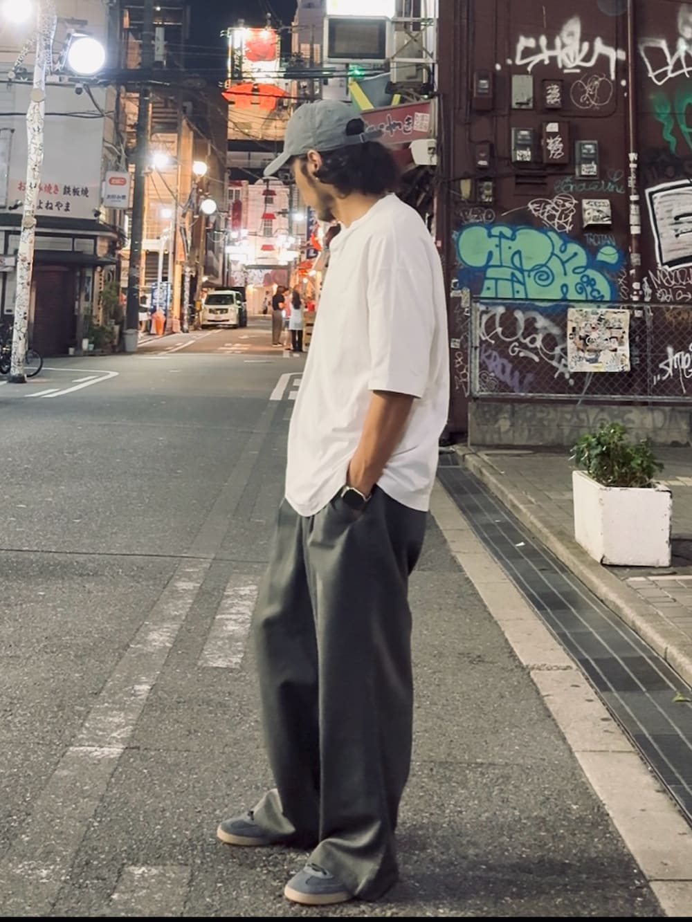 ホワイト系のTシャツ/カットソー、グレー系のスニーカー、グレー系のスラックスを着用したメンズの夏コーディネートの3枚目の写真